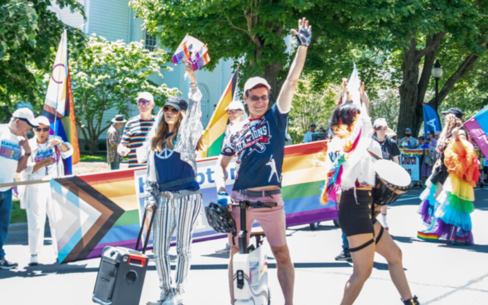 Photo of Tom House and friends (Lynn Bleu, Mila Tina) marching through the Third Annual Hamptons Pride Parade in 2024